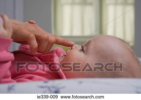 Mother touching face of baby View Large Photo Image Stock Photo - Mother touching face of baby. Fotosearch