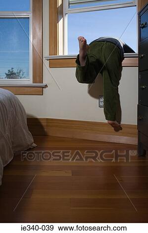 Boy climbing out of window View Large Photo Image Stock Photo - Boy climbing out of window. Fotosearch