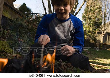 Stock Image - Boy playing with fire. Fotosearch