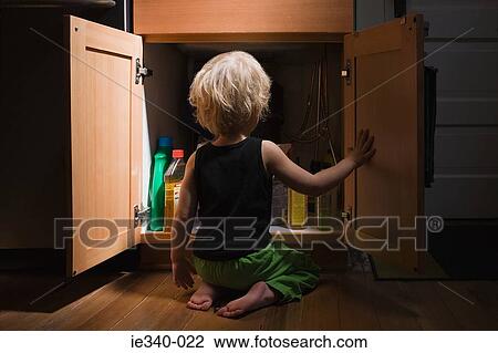 Little boy opening cupboard of cleaning products View Large Photo Image Stock Image - Little boy opening cupboard of cleaning products. Fotosearch