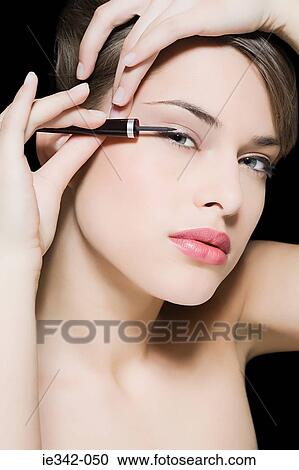 Woman applying eyeliner View Large Photo Image Stock Image - Woman applying eyeliner. Fotosearch