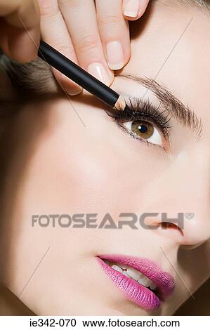 Woman applying eyeliner View Large Photo Image Stock Image - Woman applying eyeliner. Fotosearch