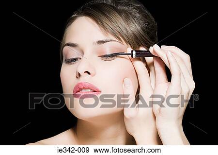 Woman applying eyeliner View Large Photo Image Stock Photo - Woman applying eyeliner. Fotosearch