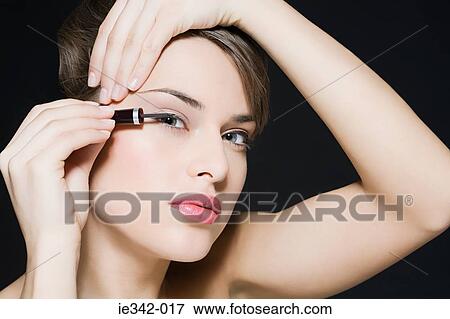 Woman applying eyeliner View Large Photo Image Stock Photo - Woman applying eyeliner. Fotosearch