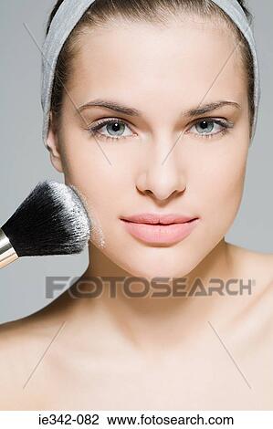 Woman applying face powder View Large Photo Image Stock Image - Woman applying face powder. Fotosearch