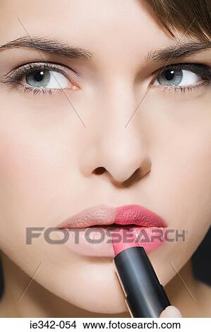 Woman applying lipstick View Large Photo Image Picture - Woman applying lipstick. Fotosearch
