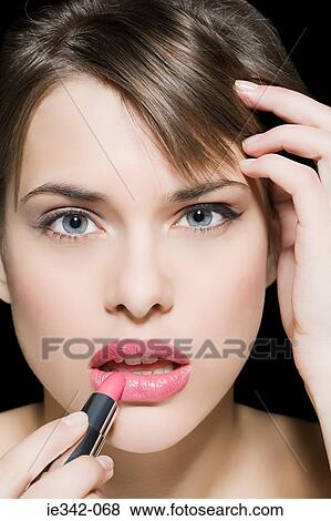 Woman applying lipstick View Large Photo Image Stock Photo - Woman applying lipstick. Fotosearch