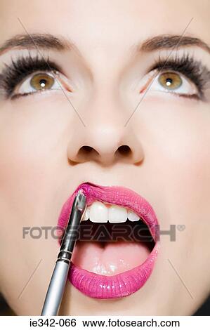 Woman applying lipstick View Large Photo Image Stock Photograph - Woman applying lipstick. Fotosearch