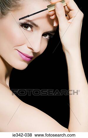 Woman applying makeup View Large Photo Image Stock Photo - Woman applying makeup. Fotosearch