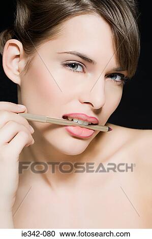 Woman biting lip liner View Large Photo Image Stock Image - Woman biting lip liner. Fotosearch