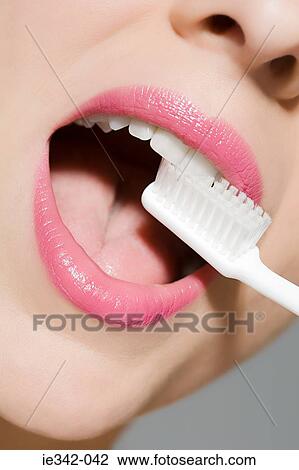 Stock Image - Woman brushing teeth. Fotosearch