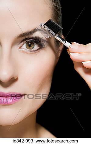Stock Image - Woman combing her eyebrow. Fotosearch