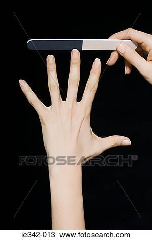 Stock Image - Woman filing her nails. Fotosearch