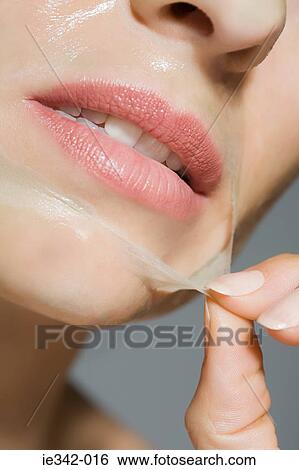 Stock Photograph - Woman peeling face mask. Fotosearch
