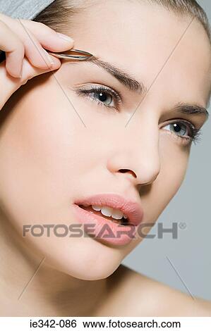 Woman plucking eyebrow View Large Photo Image Stock Photograph - Woman plucking eyebrow. Fotosearch