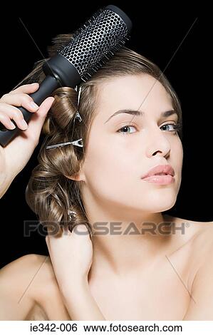 Woman styling her hair View Large Photo Image Stock Photograph - Woman styling her hair. Fotosearch