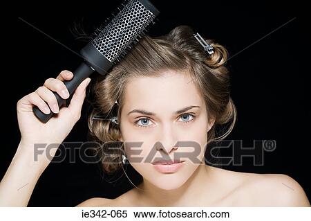 Woman styling her hair View Large Photo Image Stock Photography - Woman styling her hair. Fotosearch