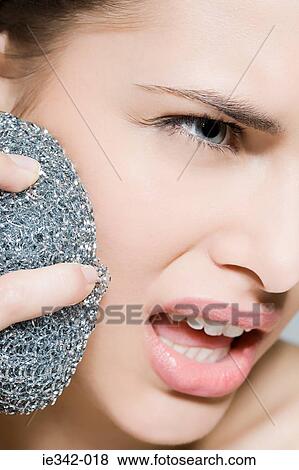 Woman using scouring pad on her face View Large Photo Image Stock Photo - Woman using scouring pad on her face. Fotosearch