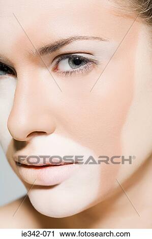 Stock Image - Woman with different colours on her face. Fotosearch
