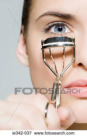 Woman with eyelash curler View Large Photo Image Stock Photo - Woman with eyelash curler. Fotosearch
