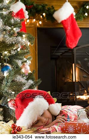 Girl sleeping by christmas gifts View Large Photo Image Picture - Girl sleeping by christmas gifts. Fotosearch