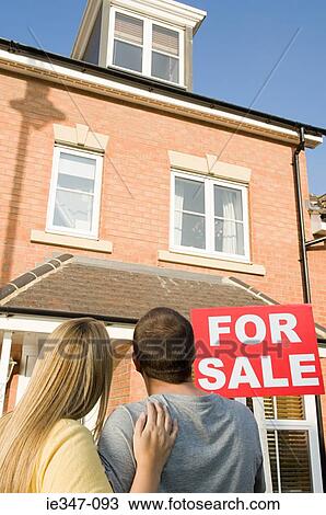 Stock Image - Couple looking at house for sale. Fotosearch