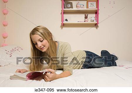 Girl reading a book in room View Large Photo Image Stock Photography - Girl reading a book in room. Fotosearch