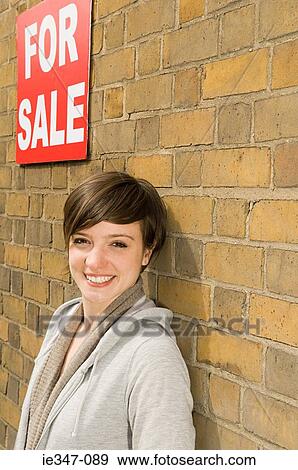Young woman and for sale sign View Large Photo Image Stock Photo - Young woman and for sale sign. Fotosearch