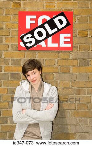 Young woman and sold sign View Large Photo Image Stock Image - Young woman and sold sign. Fotosearch