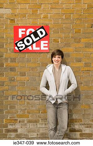Young woman and sold sign View Large Photo Image Stock Photo - Young woman and sold sign. Fotosearch