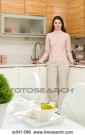 Young woman in kitchen View Large Photo Image Stock Image - Young woman in kitchen. Fotosearch