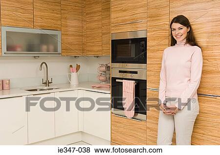Young woman in kitchen View Large Photo Image Stock Photo - Young woman in kitchen. Fotosearch