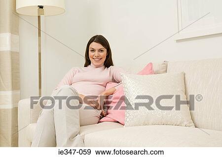 Stock Photo - Young woman on sofa. Fotosearch