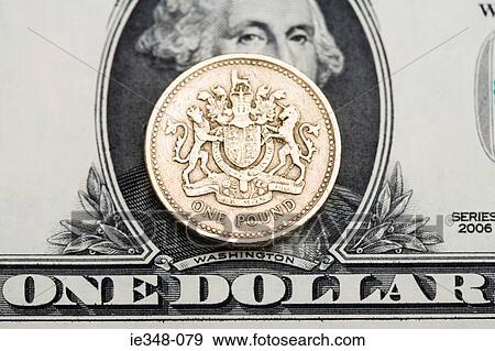Pound coin on dollar bill View Large Photo Image Stock Photo - Pound coin on dollar bill. Fotosearch