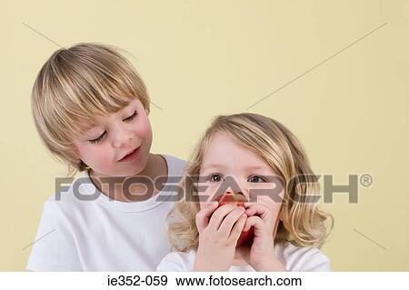 Boy and girl eating apple View Large Photo Image Stock Photo - Boy and girl eating apple. Fotosearch