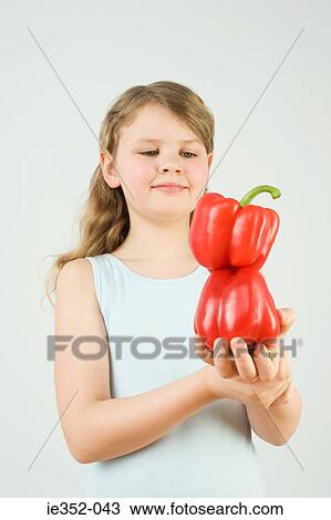Stock Image - Girl balancing peppers. Fotosearch