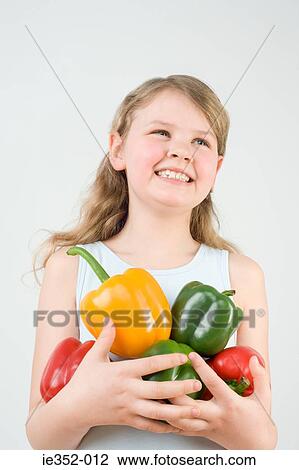 Stock Image - Girl holding peppers. Fotosearch