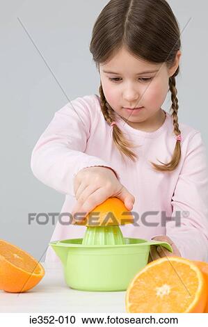 Stock Image - Girl juicing oranges. Fotosearch