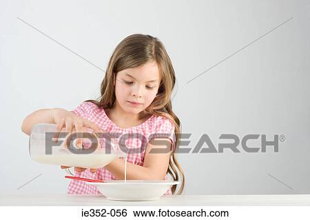 Girl pouring milk View Large Photo Image Stock Photograph - Girl pouring milk. Fotosearch