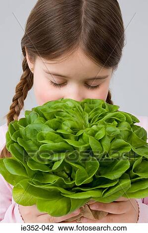 Stock Image - Girl smelling lettuce. Fotosearch