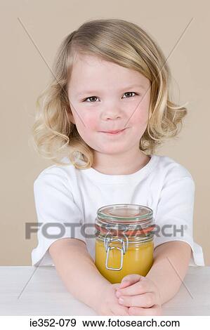 Girl with jar of lemon curd View Large Photo Image Stock Photo - Girl with jar of lemon curd. Fotosearch