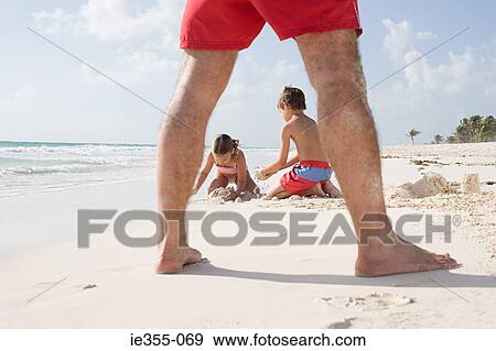 Stock Photo - A family playing on a beach. Fotosearch