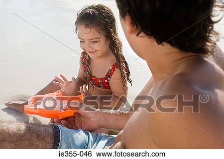 A father and daughter playing on a beach View Large Photo Image Stock Photograph - A father and daughter playing on a beach. Fotosearch