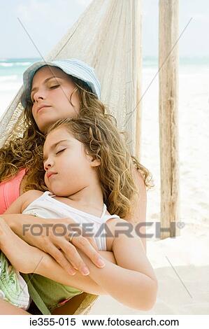 Stock Photography - A mother and daughter sleeping on a hammock. Fotosearch