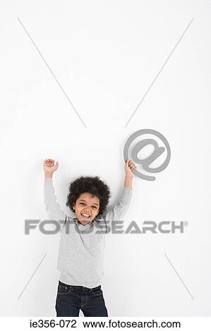 Stock Image - Boy holding an at symbol. Fotosearch