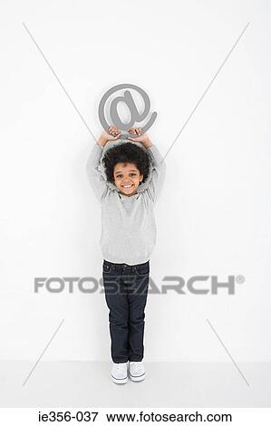 Stock Photo - Boy holding an at symbol. Fotosearch