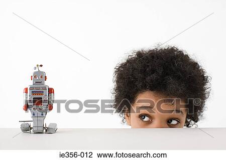Stock Image - Boy looking at robot. Fotosearch