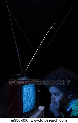 Stock Photograph - Boy looking at tv screen. Fotosearch