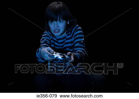 Stock Photo - Boy playing video game. Fotosearch