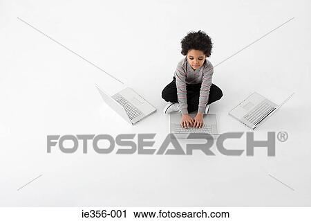 Stock Image - Boy with three laptops. Fotosearch